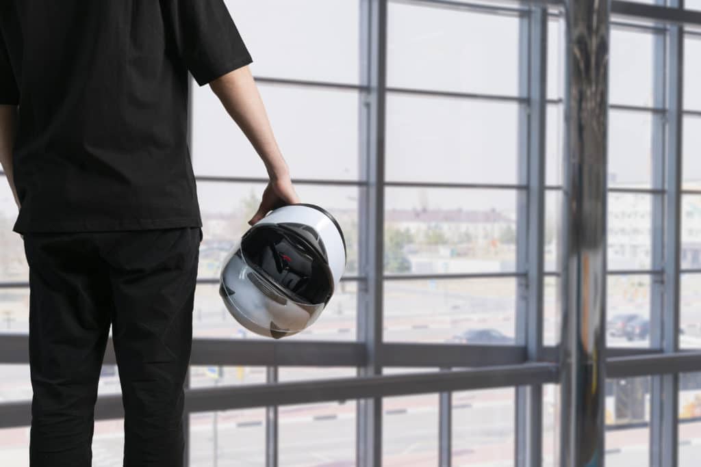 a young person holding white race helmet for motorsport